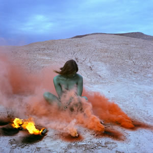 Woman sitting in orange smoke